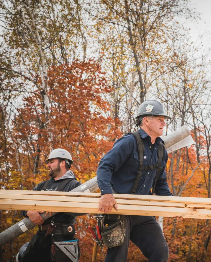 Deux hommes transportant des matériaux de construction.